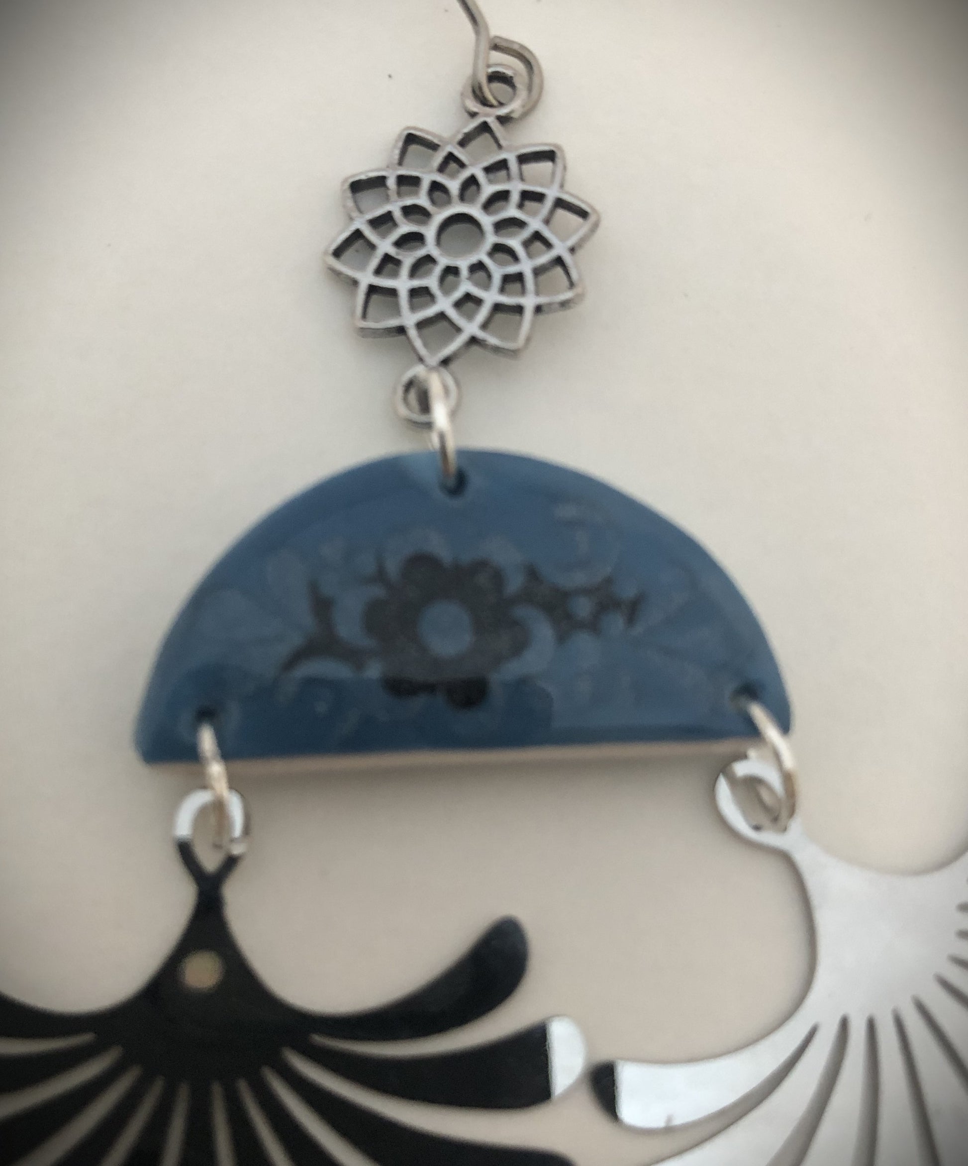 Boucles comportant un dessin floral noir et vernis pailleté