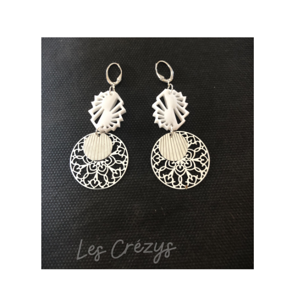 Boucles dormeuses composées d'une pampille en résine blanche , d'une rosace sculptée et d'un cercle en acier ciselé