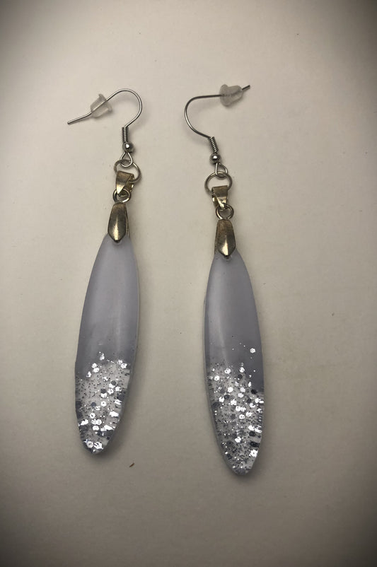 Boucles ovales blanches et paillettes argentées